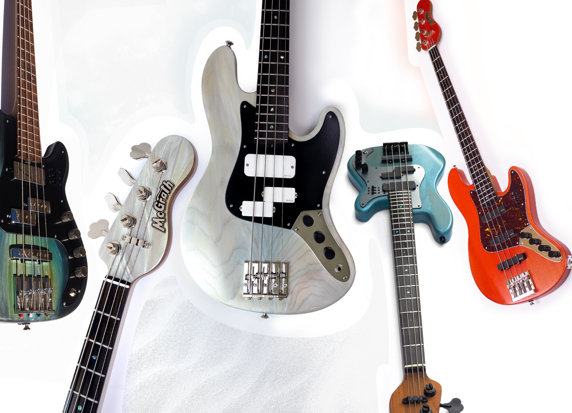 Five bass guitars of different colors and designs on a white background